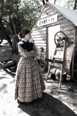 A Pioneer Woman Re-Enactor Outside her Cabin